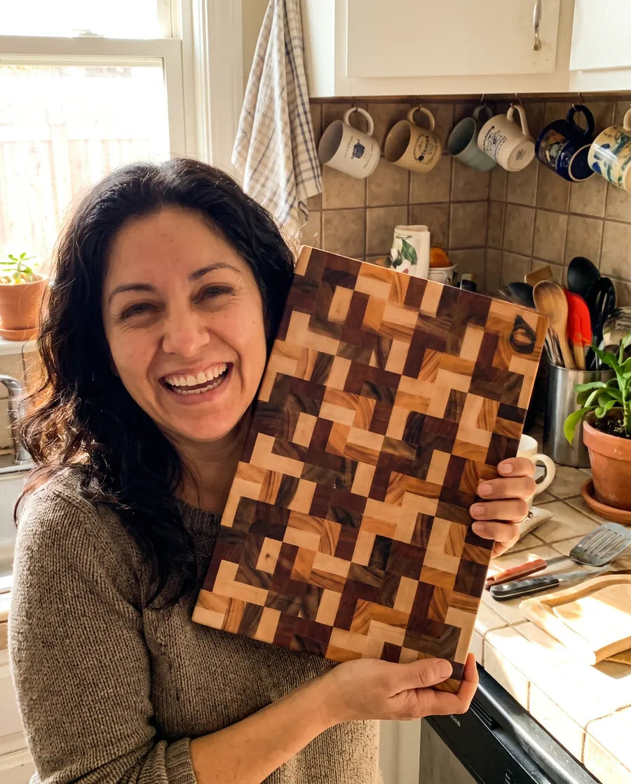 Home cook smiling with a Notorious end-grain chopping board
