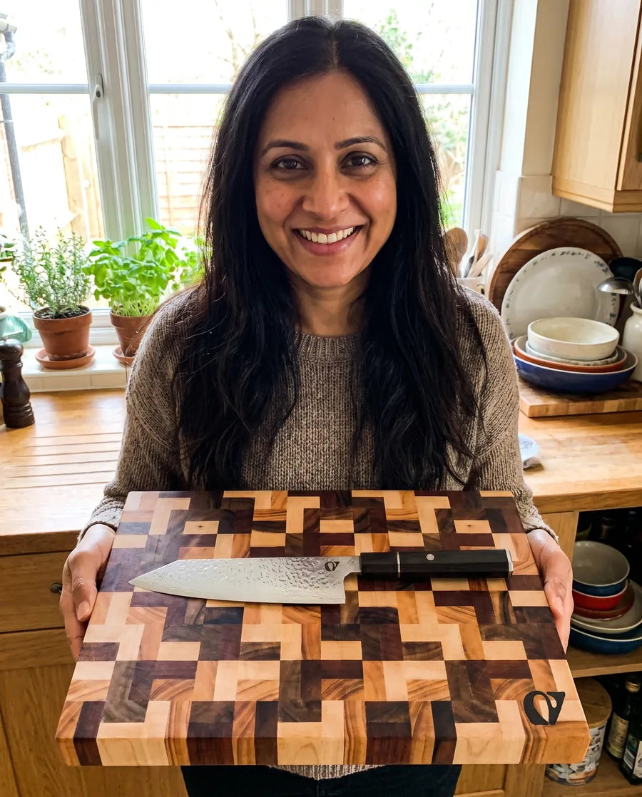 Home cook presenting the Notorious chef's knife on its end-grain board