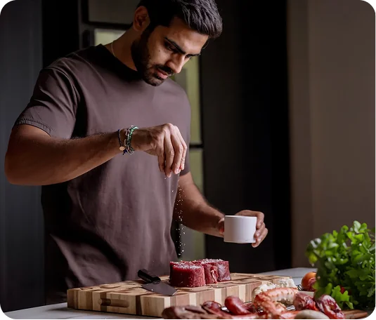 Home cook seasoning food on a Notorious end-grain chopping board