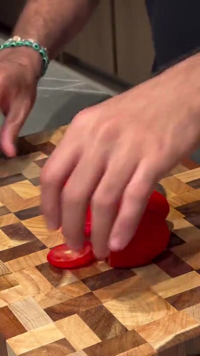 The Notorious Damascus chef's knife slicing a tomato